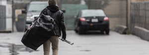 person carrying a hockey bag